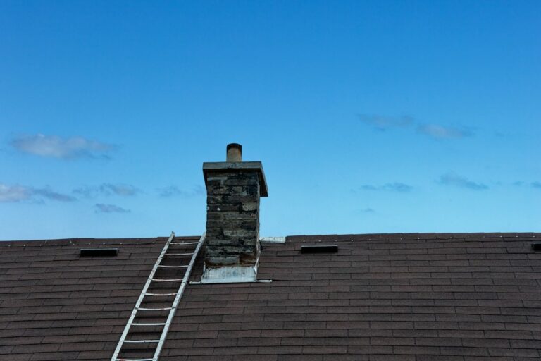 Homeowner examining roof shingles and flashing from the ground beside a residential house.